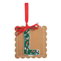 A decorative hanging ornament shaped like the letter L, made from green glitter with colorful Christmas light bulbs and a red ribbon loop at the top, displayed on a brown kraft card against a white background.