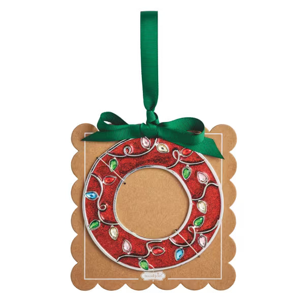 A square kraft paper ornament with scalloped edges, featuring a red wreath design with embroidered holiday lights and a green ribbon hanging loop at the top.