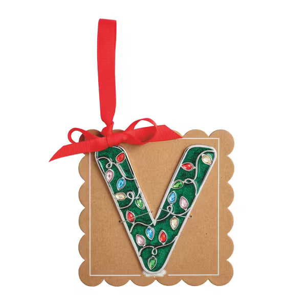 A decorative hanging ornament shaped like the letter V, decorated with green glitter and colorful Christmas light bulbs, attached to a brown kraft paper backing with a red ribbon loop.