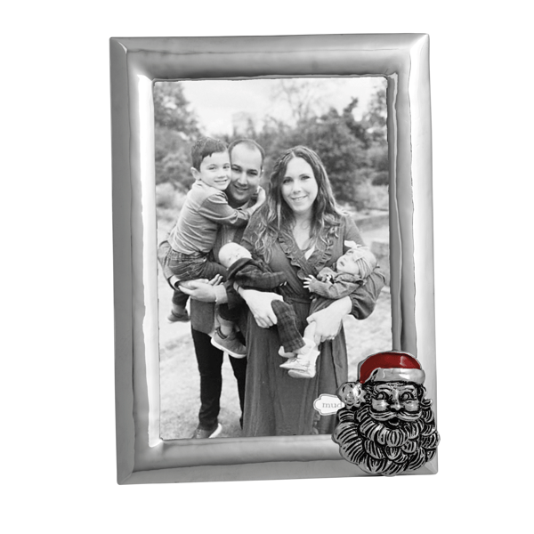 A silver-toned rectangular photo frame with a black-and-white family portrait inside, plus a small Santa face decoration at the lower right corner of the frame.