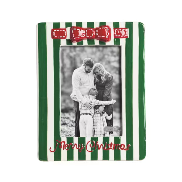 A ceramic Christmas picture frame with green and white vertical stripes, a red bow at the top, and 'Merry Christmas' written in red script at the bottom. It features a sample black-and-white photo of a family and is shown on a plain white background.