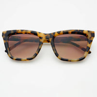 Tortoiseshell sunglasses with brown lenses on a white background