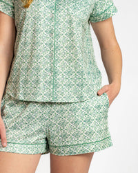 Green patterned pajama set worn by a person on a white background