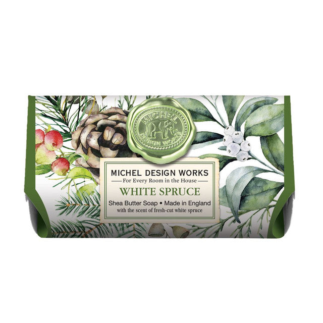 Bar of soap with a decorative packaging featuring greenery and a logo, labeled 'White Spruce' by Michel Design Works.
