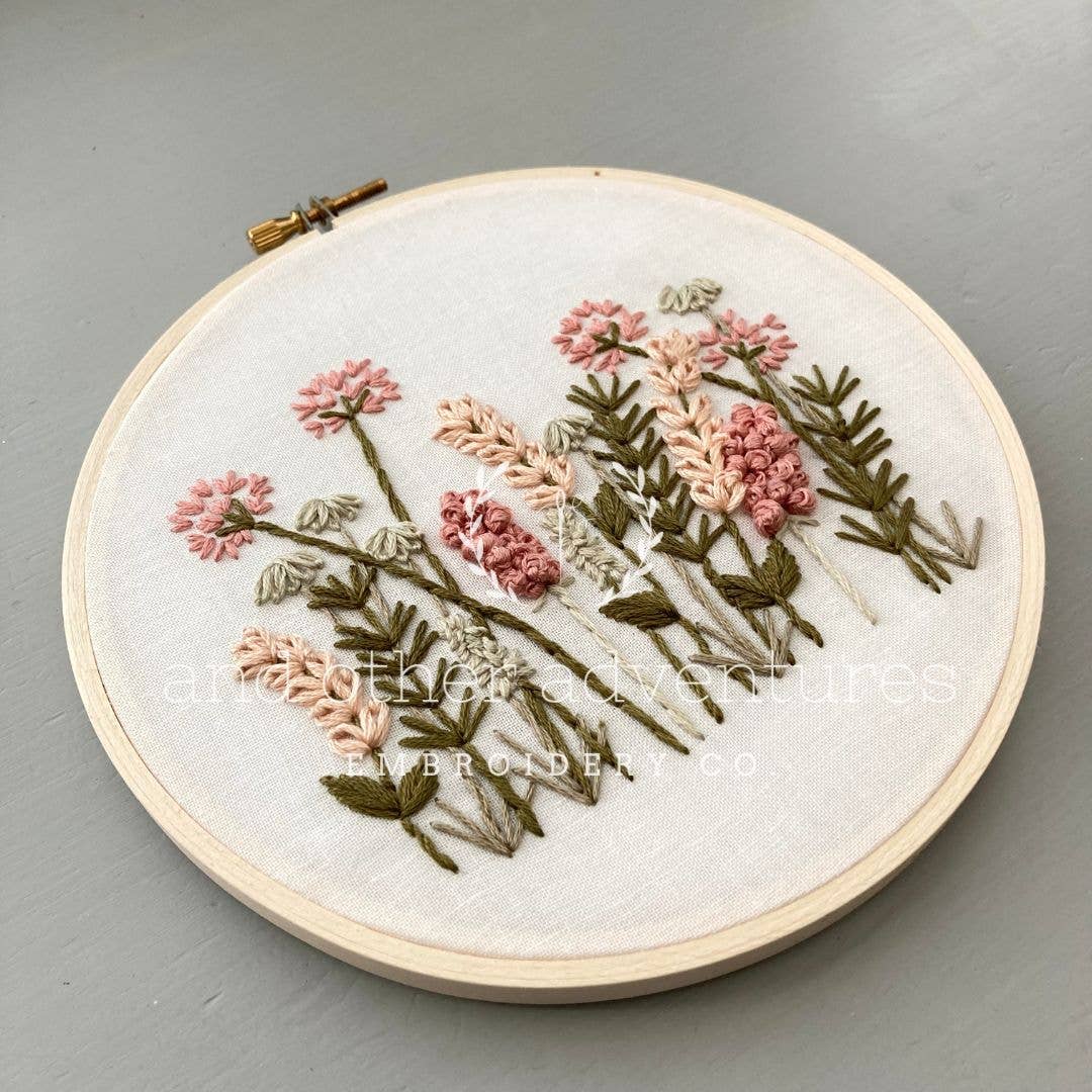 Embroidery hoop with floral design on a gray background