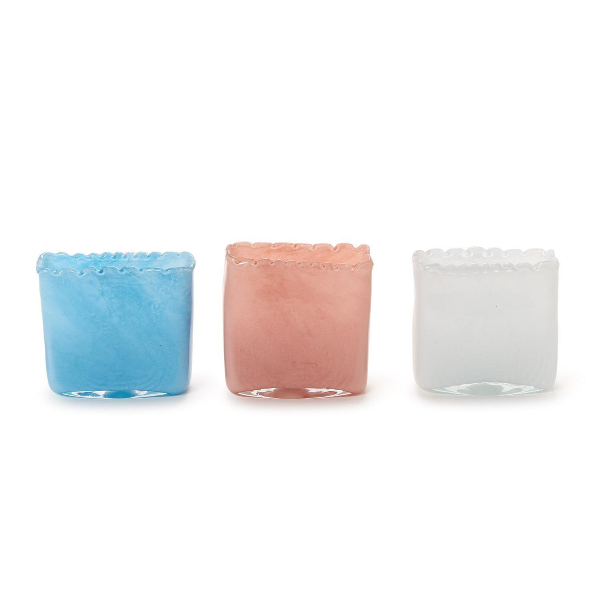 Three small glass containers with textured rims in blue, pink, and white on a white background