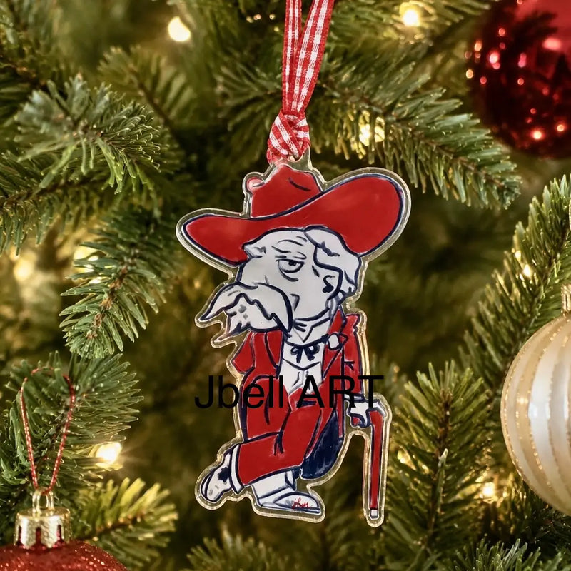 A Christmas ornament shaped like a cartoon figure in a red hat and red coat, hanging on a decorated Christmas tree with lights and other ornaments in the background.