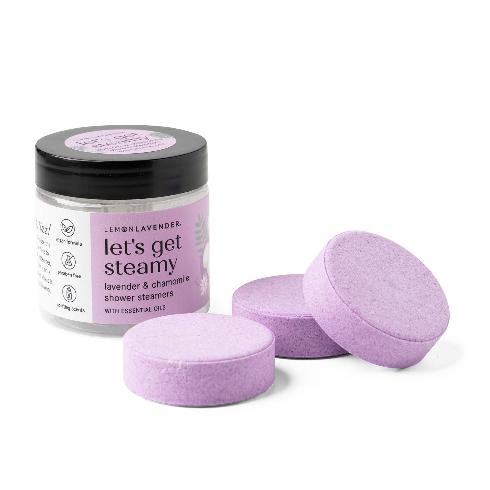 Jar of 'let's get steamy' shower steamers with three purple tablets on a white background