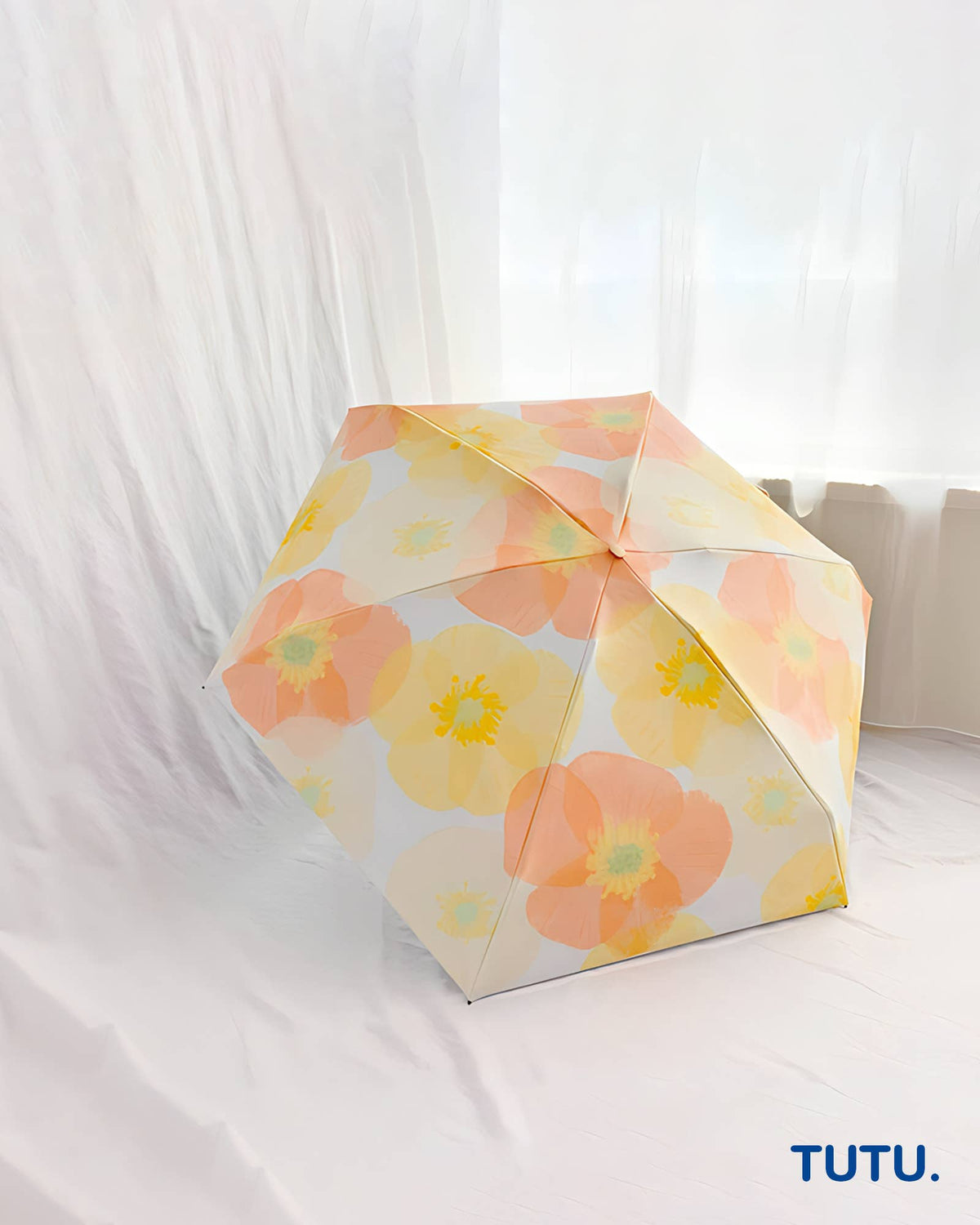Floral-patterned umbrella on a white background with 'TUTU.' branding.