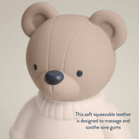 Teddy bear teether toy on a beige background.