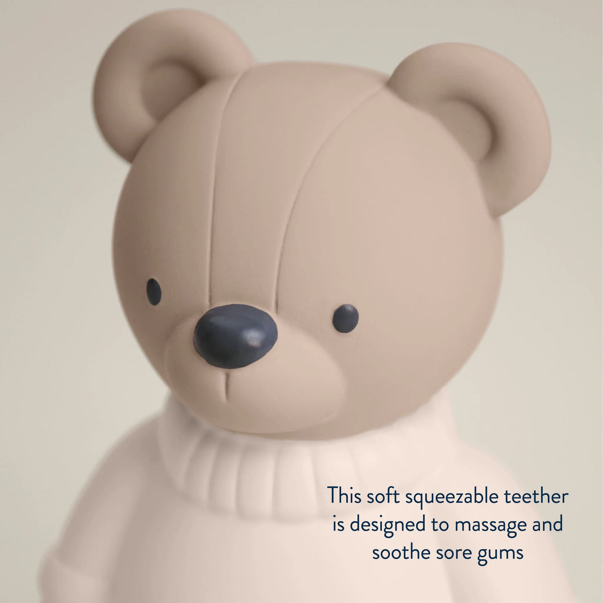 Teddy bear teether toy on a beige background.