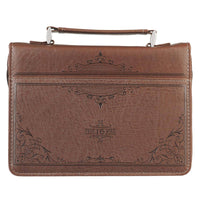 Brown leather bag with embossed designs on a white background