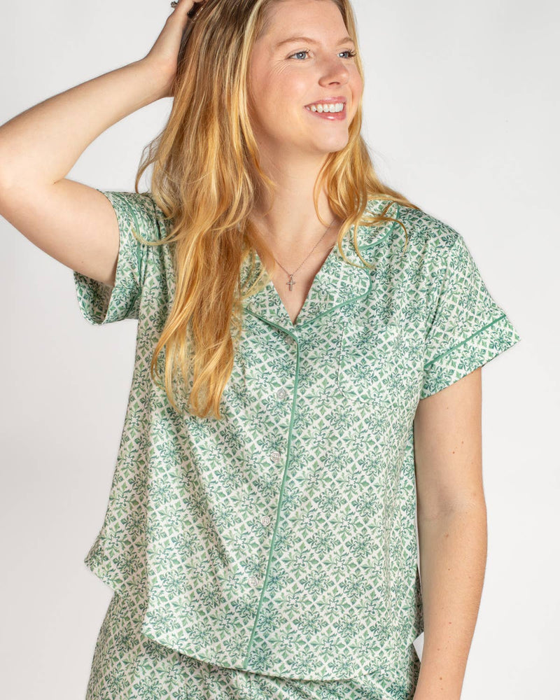 Woman wearing a green patterned shirt against a white background