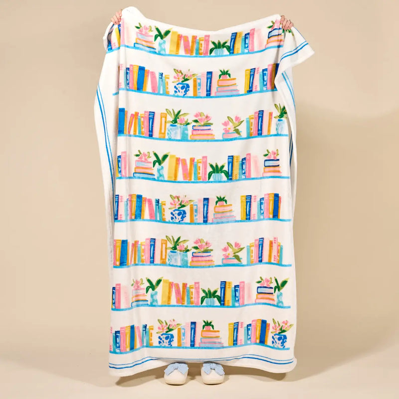 Colorful book-themed towel draped over a chair on a beige background