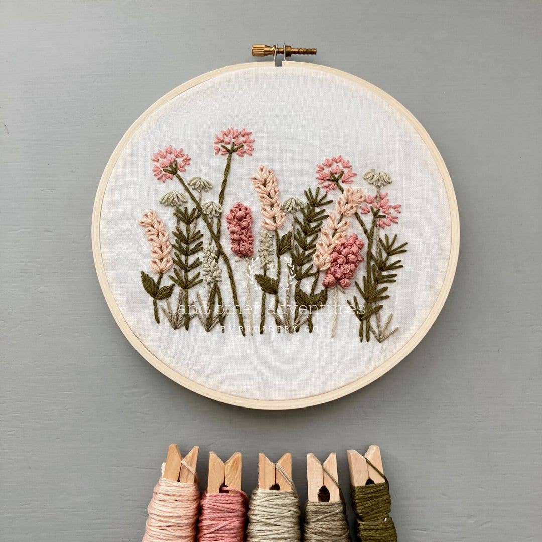 Embroidery hoop with floral design on a gray background