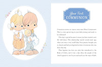 A baby first communion card featuring a cute cartoon illustration of a blonde girl and a pink-haired boy holding a baby doll, alongside printed text that reads 'Your First COMMUNION' and a congratulatory message.
