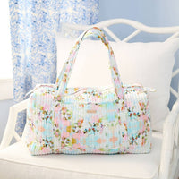 Floral patterned bag on a white chair with a light blue background