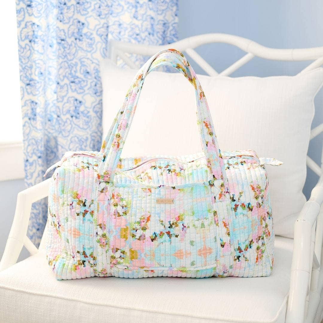 Floral patterned bag on a white chair with a light blue background