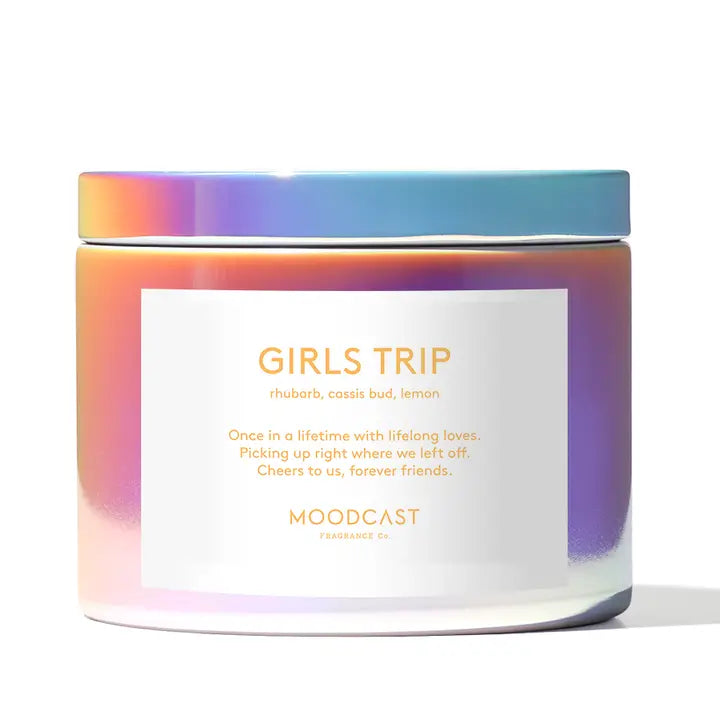 Candle with 'Girls Trip' label and colorful lid on a white background