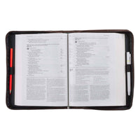 Open book in a black leather cover with pen slots on a white background