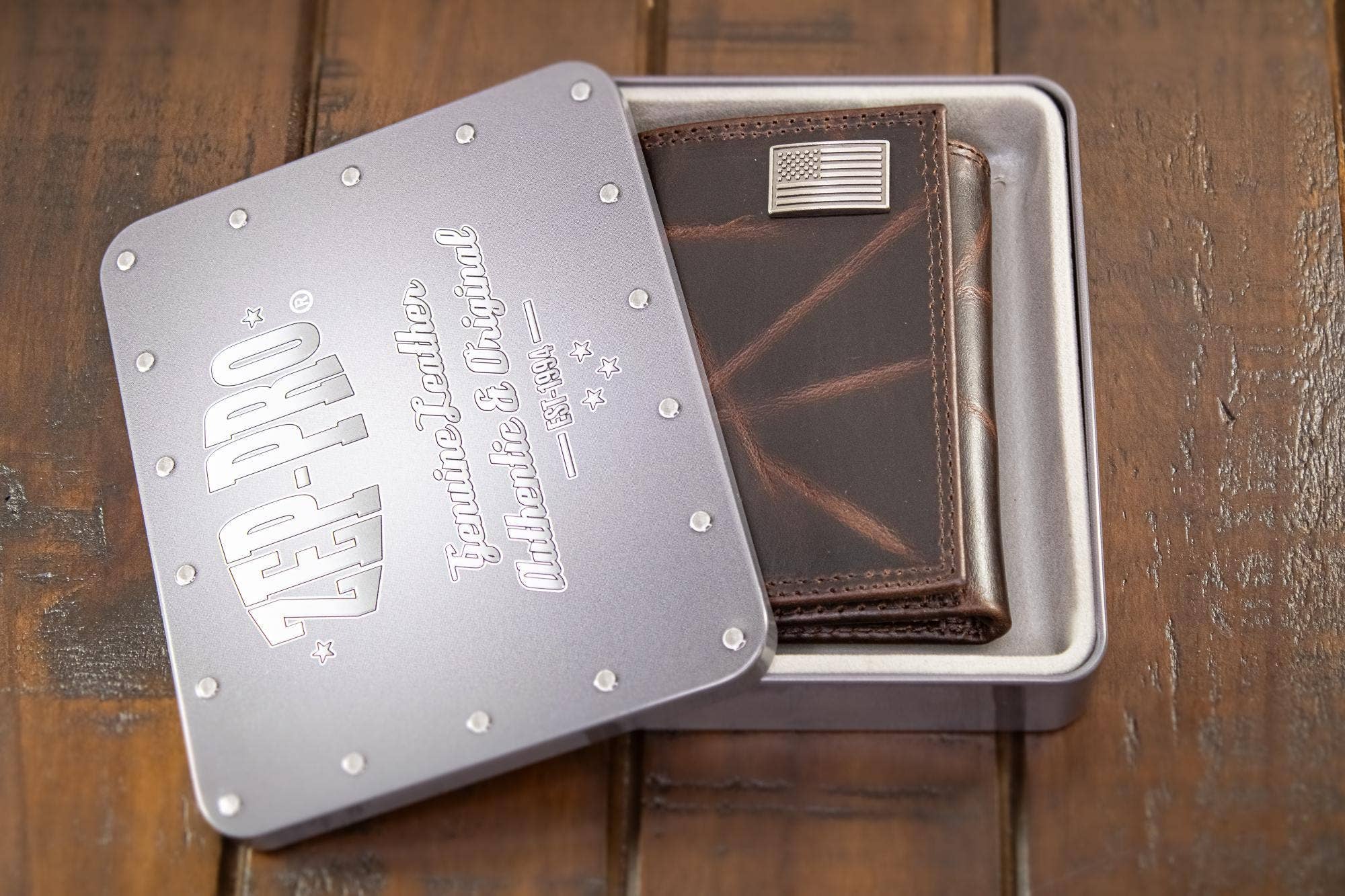 Brown leather wallet in a metal box with 'Red Wing' branding on a wooden surface