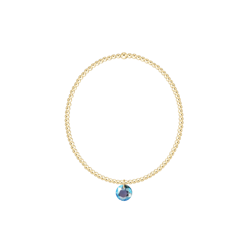 Gold necklace with a blue gemstone pendant on a white background