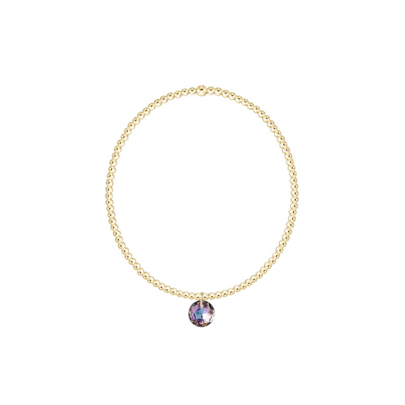 Gold necklace with a purple pendant on a white background