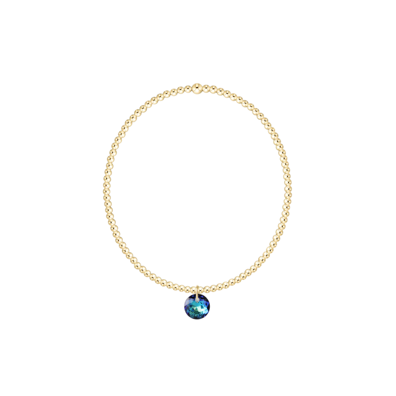 Gold necklace with a blue gemstone pendant on a white background