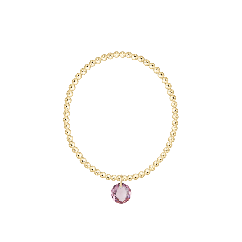 Gold beaded bracelet with pink gemstone charm