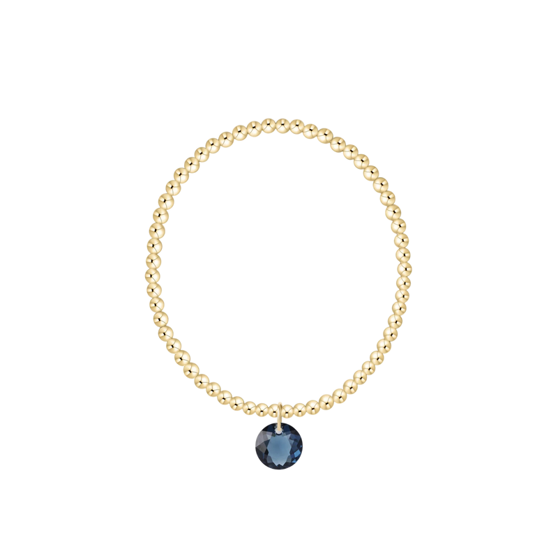 Gold beaded bracelet with blue charm