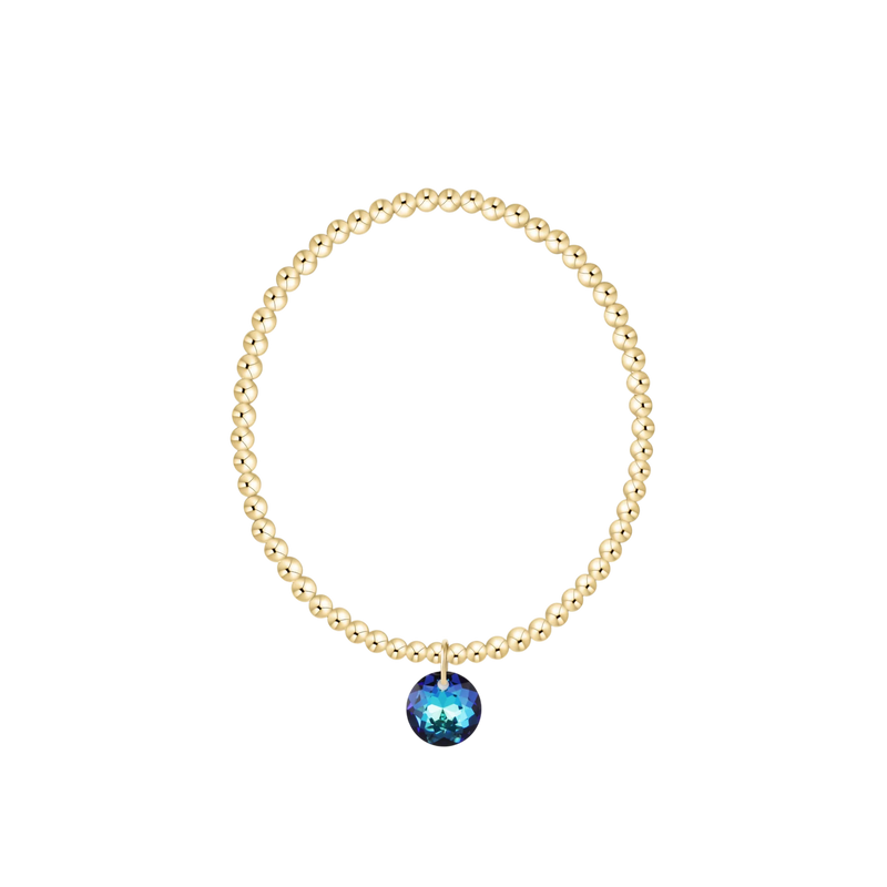Gold bracelet with a blue gemstone on a white background