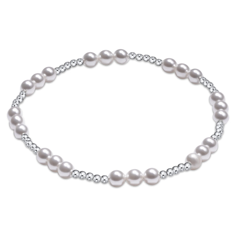 A delicate silver-toned beaded bracelet featuring alternating smooth round pearls and tiny metallic beads, displayed on a clean white background.