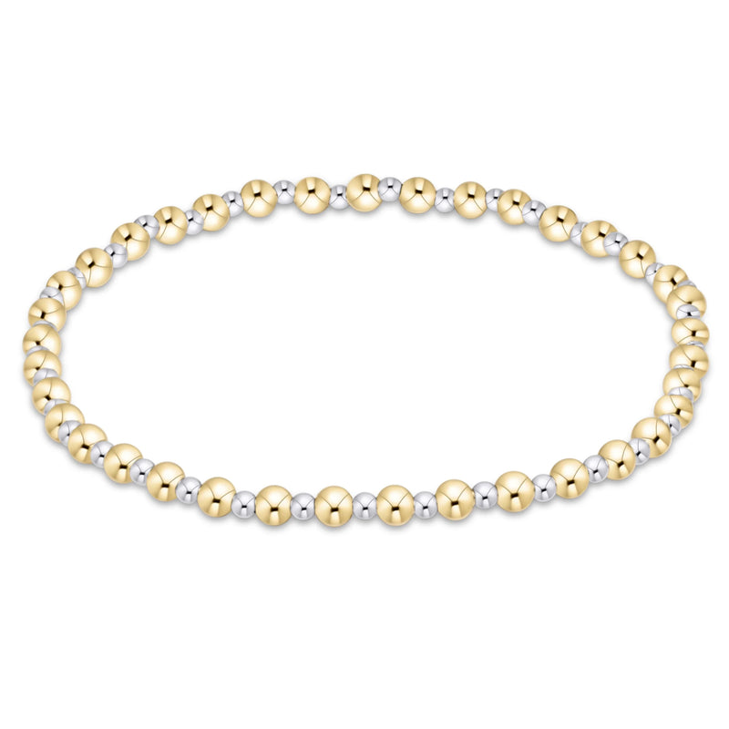 A beaded stretch bracelet featuring alternating polished yellow gold and silver-toned round beads, arranged in an oval shape on a clean white background.