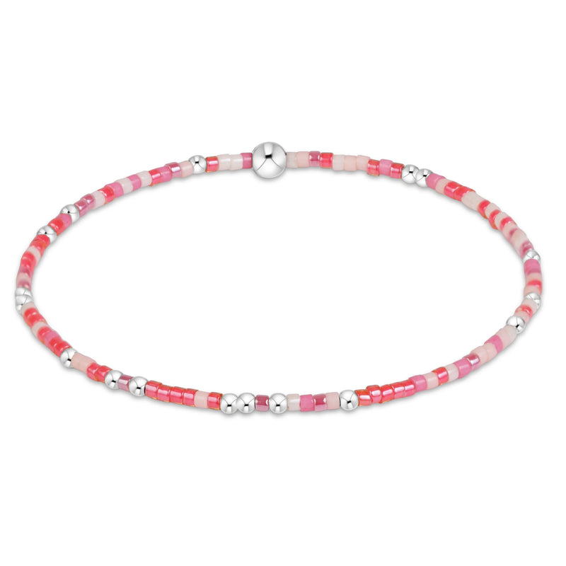 A beaded stretch bracelet featuring alternating translucent pink and white beads with polished silver spacer beads and a central silver magnetic clasp, shown on a plain white background.