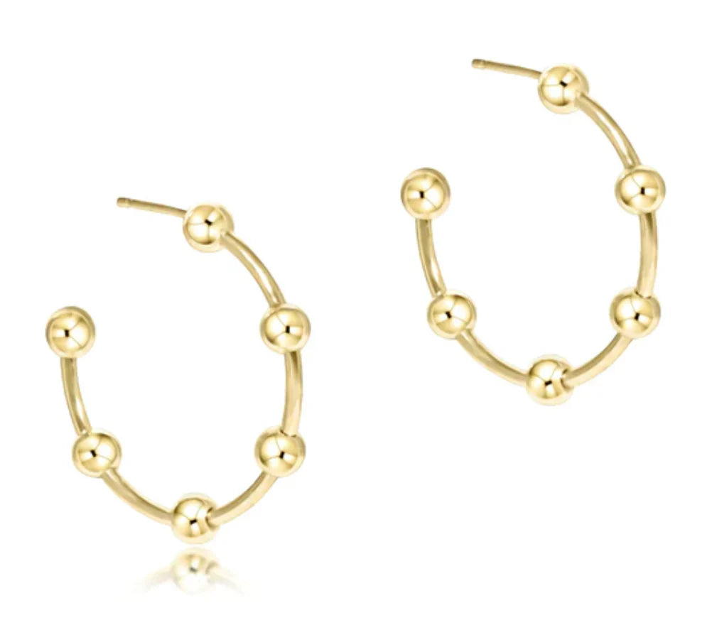 Gold hoop earrings with spherical accents on a white background

