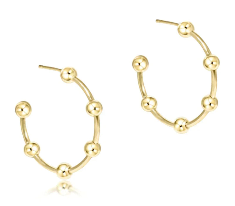 Gold hoop earrings with spherical accents on a white background

