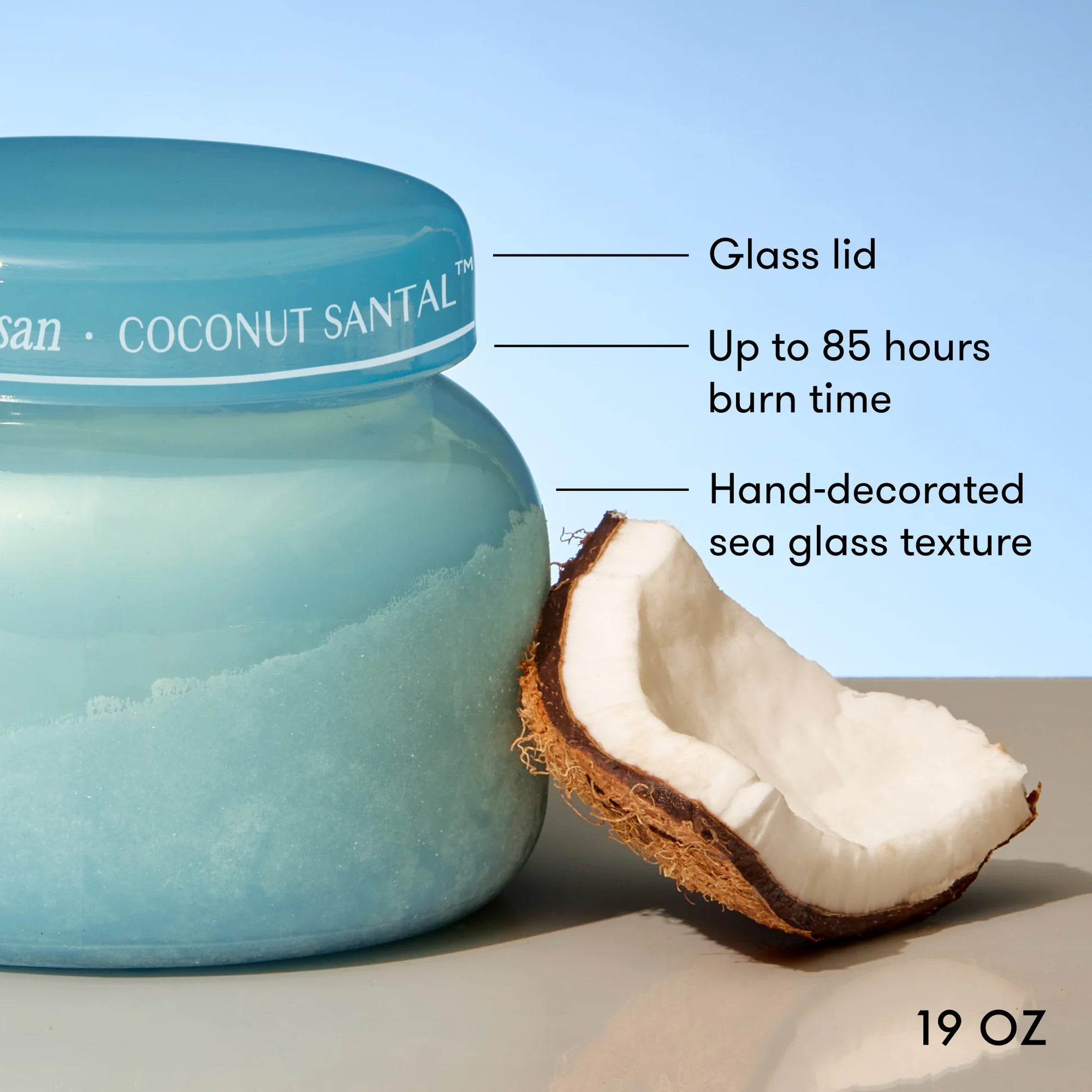 Coconut scented jar with a glass lid, coconut half, and product details on a light background