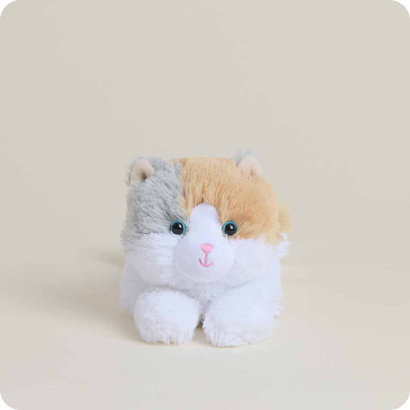 Plush toy cat with a white chest and brown ears on a beige background
