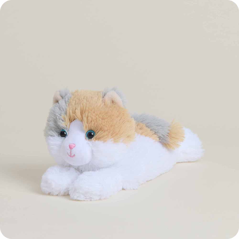 Plush toy resembling a cat with a beige, white, and gray color scheme on a light beige background.