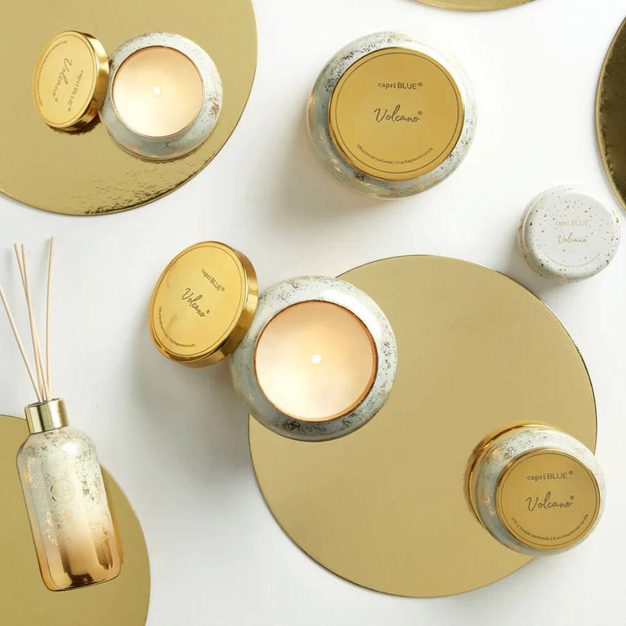 Decorative candles and diffusers with gold and white design on a light background