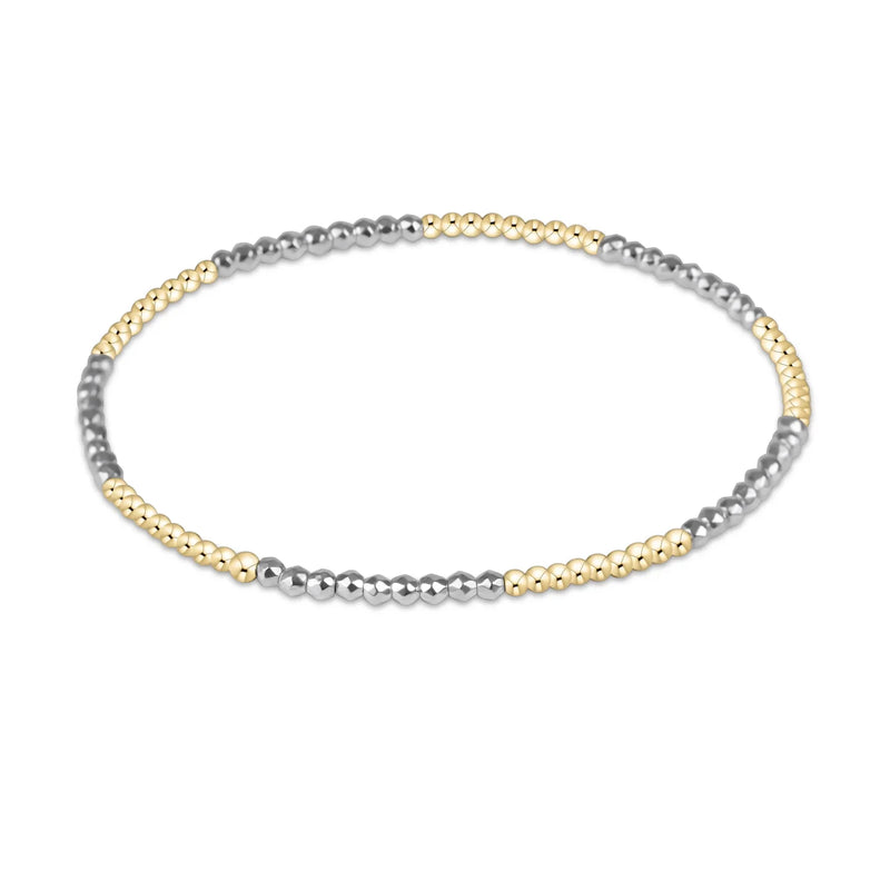 Beaded bracelet with alternating gold and silver beads on a white background