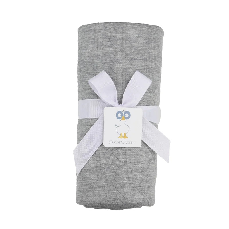 Gray fabric wrapped in white ribbon with a brand label on a white background