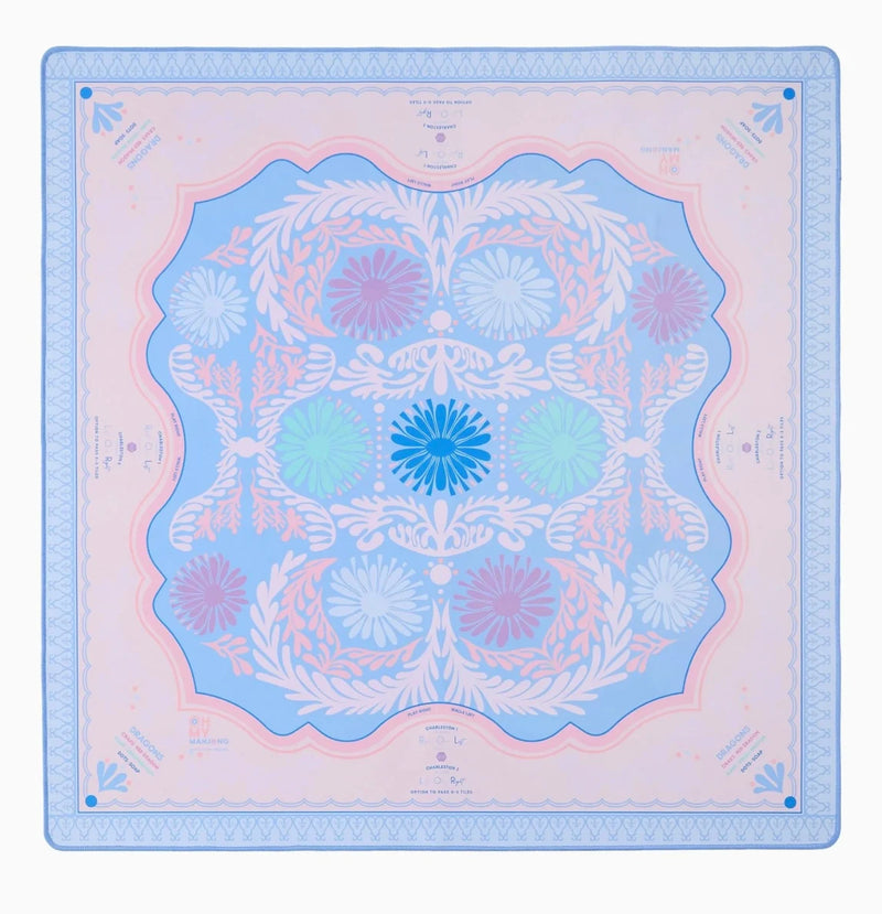 A square silk scarf featuring a symmetrical mandala pattern in pastel shades of blue, pink, and white, with a decorative border.