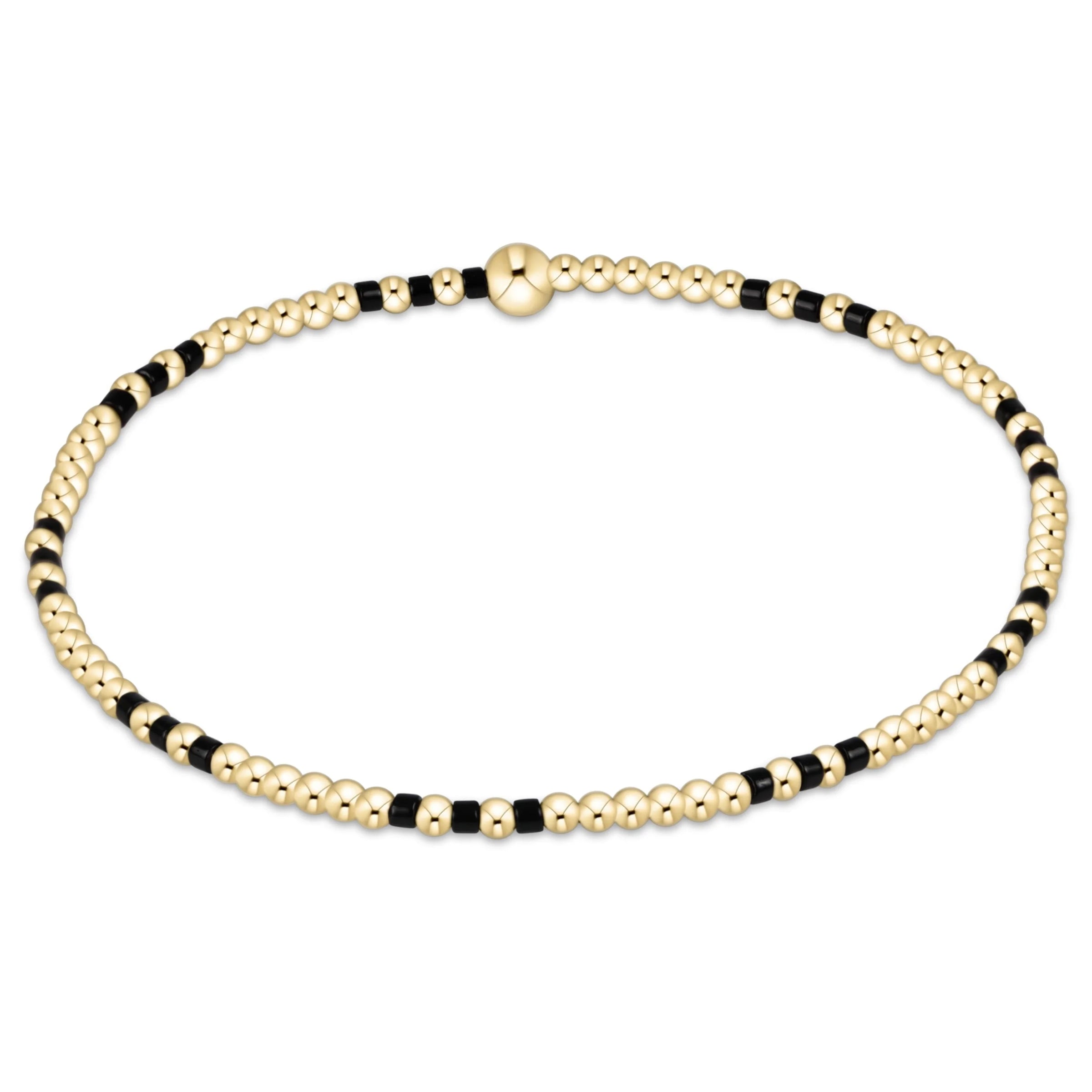 Gold and black beaded bracelet on a white background

