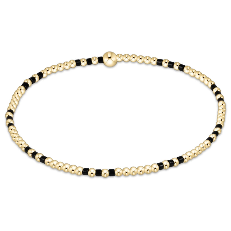 Gold and black beaded bracelet on a white background
