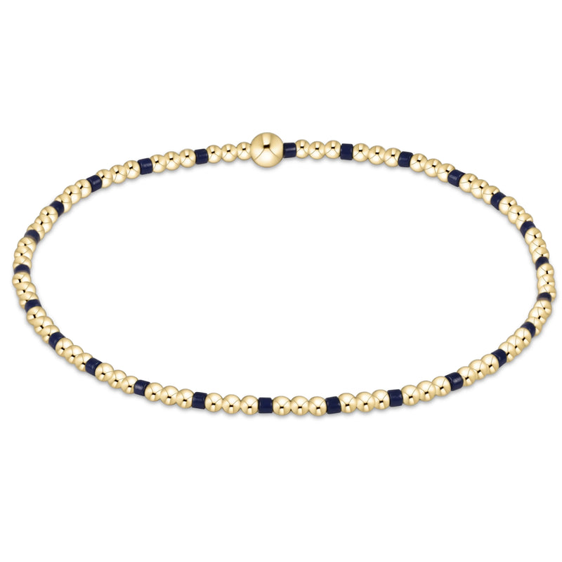Gold beaded bracelet with alternating navy 2mm beads on a white background