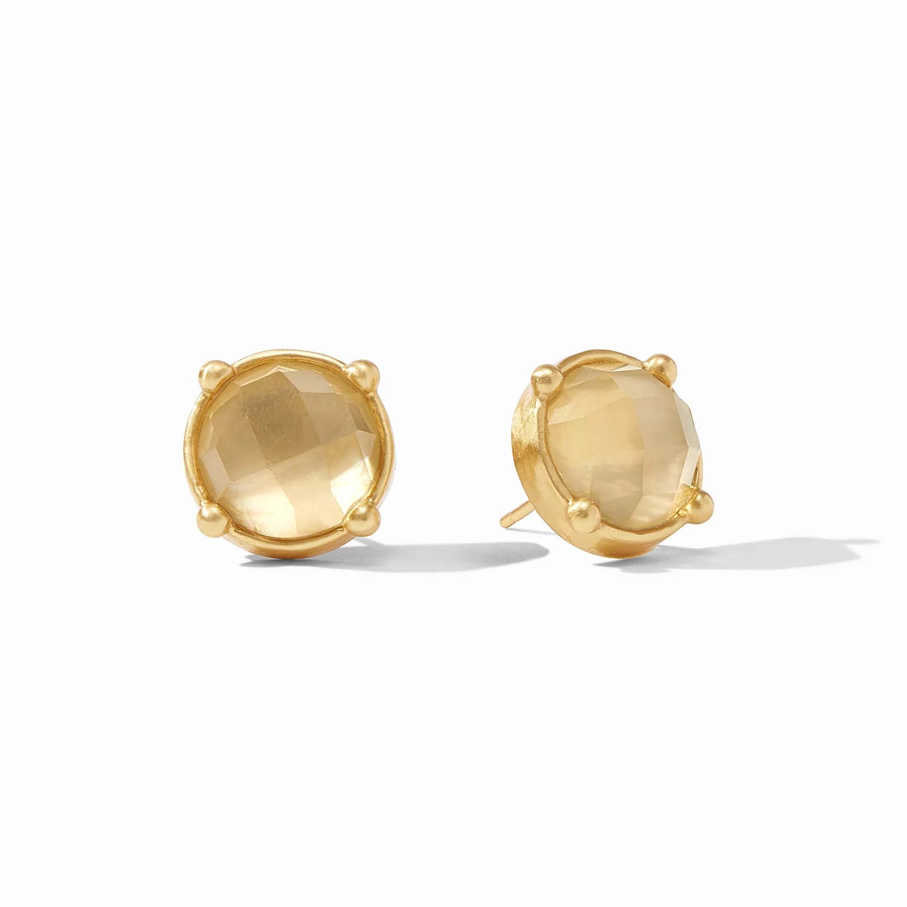 Pair of gold earrings with clear gemstones on a white background
