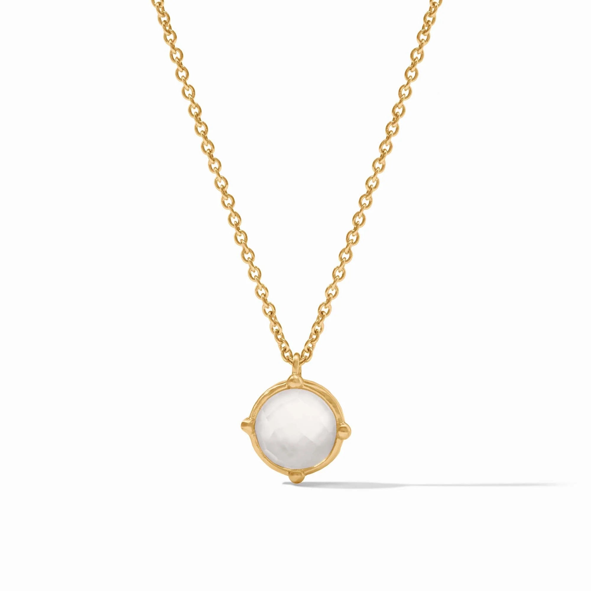 Gold necklace with a white pendant on a white background
