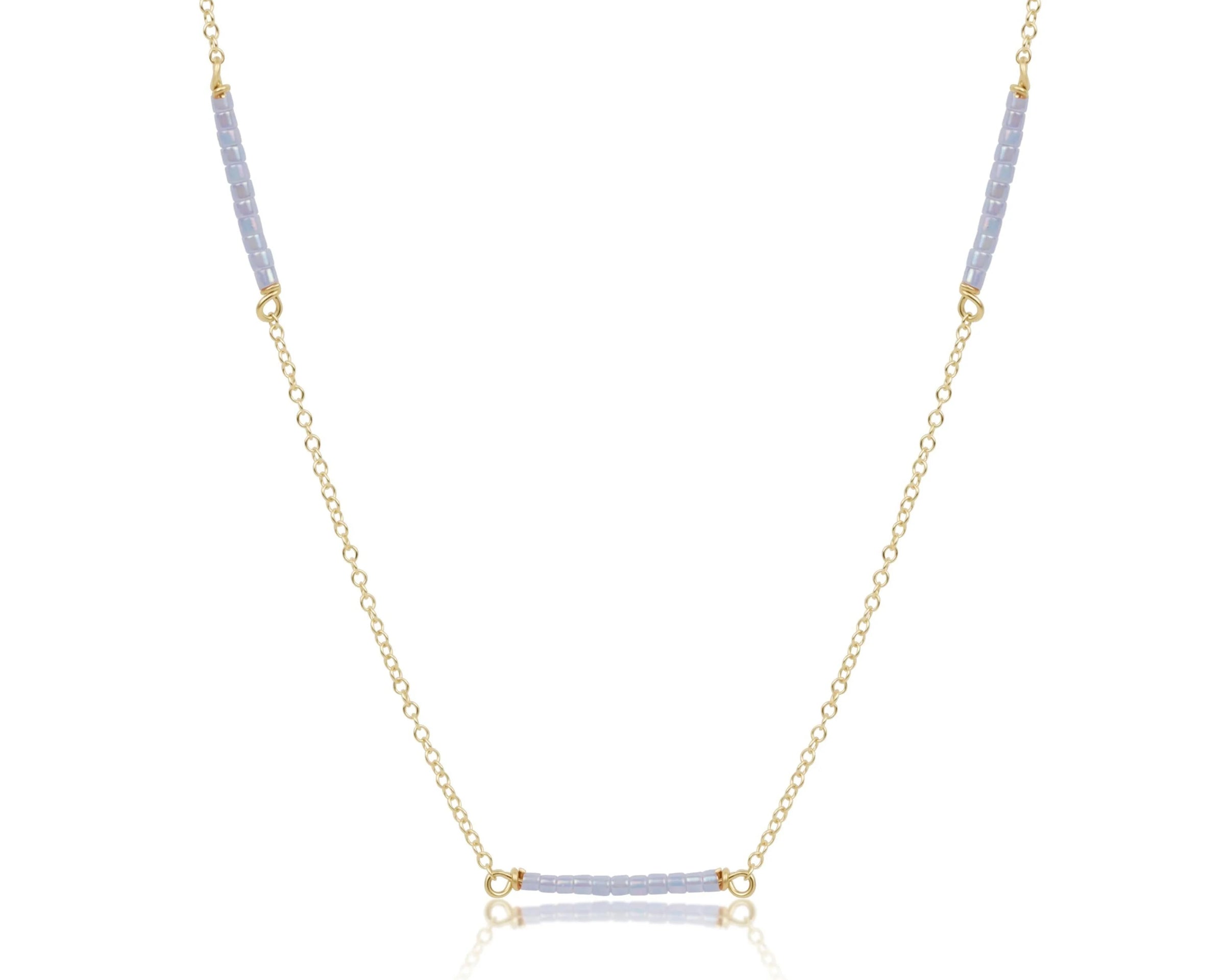 Necklace with gold chain and blue gemstones on a white background