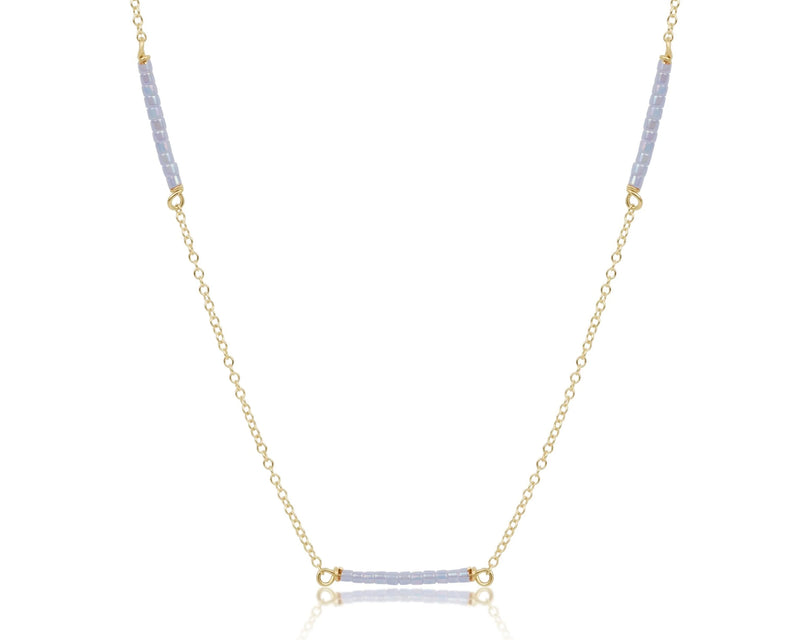 Necklace with gold chain and blue gemstones on a white background